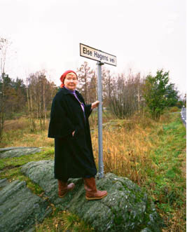 Else Hagen står ved veiskilt som viser Else Hagens Vei